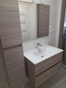 a bathroom with a sink and a mirror at Appartement lumineux et central in Propriano
