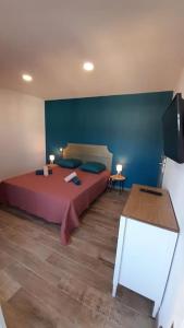 sypialnia z łóżkiem i niebieską ścianą w obiekcie Appartement lumineux et central w mieście Propriano
