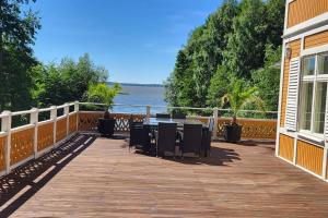 a wooden deck with chairs and a view of the water at Beautiful lake view house in Västerås