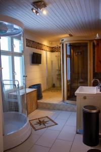 baño grande con bañera y lavamanos en Beautiful lake view house, en Västerås