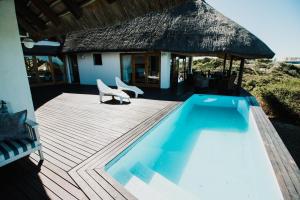 a swimming pool on a deck next to a house at Oceans Voice in Jeffreys Bay