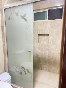 a shower with a glass door with birds on it at Hotel El Mirador in Ciudad Valles