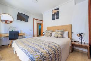 1 dormitorio con cama, escritorio y espejo en Hotel Madrid, en Torrevieja