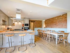 Freds Barn في Swanton Abbot: مطبخ وغرفة طعام بجدار من الطوب