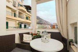 una mesa blanca en un balcón con ventana en Luxury apartment near the beach, en Makarska
