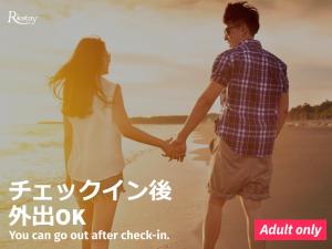 a couple holding hands while standing on the beach at Restay Tokushima Aine (Adult Only) in Tokushima