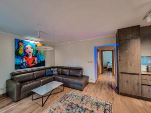 a living room with a leather couch and a table at Apartament VIP PROMENADA in Mrągowo