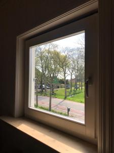 a window with a view of a street at De Smederij, guesthouse in Abbekerk