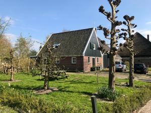 a house with trees in the front yard at De Smederij, guesthouse in Abbekerk