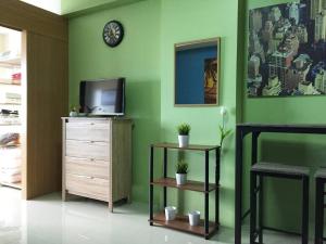 een woonkamer met een tv en een groene muur bij Best Deal NEAREST to MOA, BIGGER 1BR Wifi CableTV in Manilla