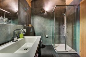 een badkamer met wastafel en douche bij Chalet le Chapeau in La Tzoumaz
