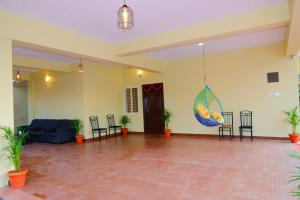una gran sala de estar con un sofá azul y sillas en The Coorg Heaven en Madikeri