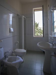 bagno bianco con servizi igienici e lavandino di Casa San Giuseppe - Isola d'Elba a Cavo