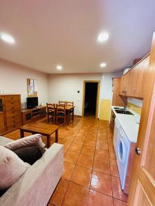 a kitchen and living room with a couch and a table at Pirineos como en casa in Bielsa