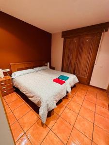 a bedroom with a bed and a tiled floor at Pirineos como en casa in Bielsa
