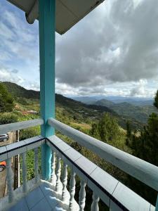 a balcony of a house with a view of the mountains at Fairy Garden Resort Kundasang in Kundasang
