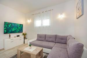 salon z kanapą i telewizorem w obiekcie Apartman Rokov w mieście Kaštela
