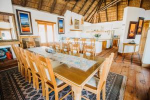 a dining room with a wooden table and chairs at Oceans Voice in Jeffreys Bay