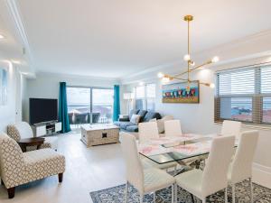 Un comedor y una sala de estar con mesa y sillas. en Regency Towers #708 West, en Pensacola Beach