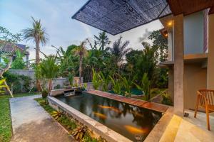Narada Suite & Villa في أوبود: بركة كوي في الحديقة الخلفية للمنزل
