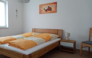 a bedroom with a bed with yellow and white sheets at Ferienwohnung Taubertraum in Weikersheim