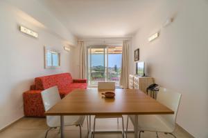 uma sala de jantar com uma mesa e uma cadeira vermelha em Don Vittorio Country Village em Taormina