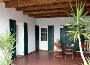 a porch with green doors and a table and chairs at Casarosa B&B in Piazzola sul Brenta