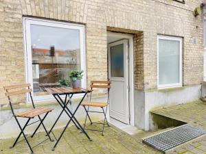 a patio with two chairs and a table and a window at aday - Charming Studio close to the Football Stadium in Aalborg