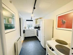 a kitchen with a table and a white refrigerator at aday - Charming Studio close to the Football Stadium in Aalborg