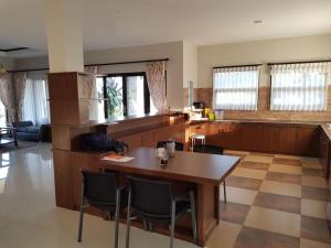 a kitchen with a wooden table and chairs at Villa Otti, Batu in Songgoriti
