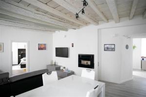 een witte woonkamer met witte muren en een tv bij Fabula Home Rental - Casa Lù in Lovere