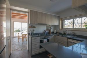 eine Küche mit Holzschränken und einer Arbeitsplatte in der Unterkunft Sa Guineu in Cadaqués