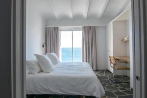 1 dormitorio con cama, escritorio y ventana en Sa Guineu, en Cadaqués