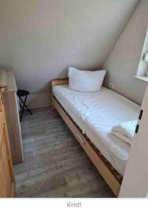 Habitación pequeña con cama con almohada. en Meerhaus Hieve en Emden