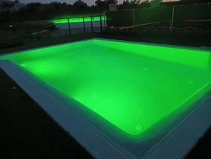 una piscina con luces verdes encima en Apartamento Buenavista con jacuzzi y jardín privado en Abadia, en Abadía