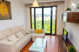 a living room with a white couch and a table at Apartagal-Urb. Traiñeira in O Vicedo