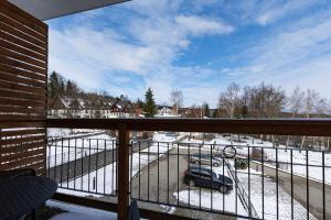 a balcony with a view of a snow covered yard at VacationClub - Cristal Resort Apartament 314 in Szklarska Poręba