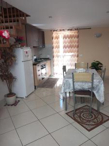 uma cozinha com uma mesa e um frigorífico branco em Billy house em Acireale
