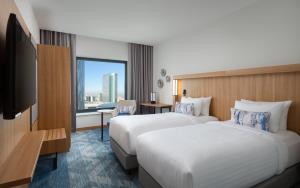 pokój hotelowy z dwoma łóżkami i telewizorem w obiekcie Courtyard by Marriott Bucharest Floreasca w Bukareszcie