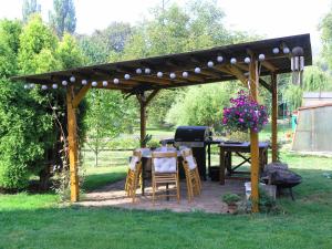 a wooden pergola with a table and a grill at Stylové podkrovní apartmány Ostrava in Ostrava