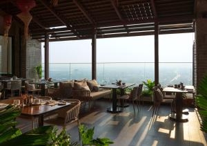 Ad Lib Hotel Khon Kaen في كون كاين: مطعم بطاولات وكراسي وأريكة