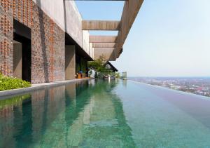 a swimming pool on the side of a building at Ad Lib Hotel Khon Kaen in Khon Kaen