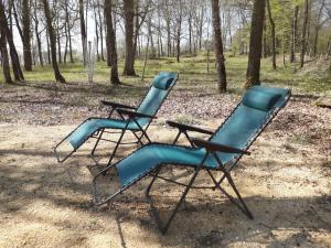 dos sillas azules están sentadas en un parque en Gite Truffière de La Garrigue, Cubjac, Dordogne, en Cubjac