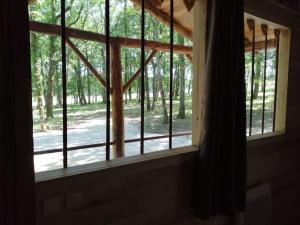 ein Fenster in einem Haus mit Waldblick in der Unterkunft Gite Truffière de La Garrigue, Cubjac, Dordogne in Cubjac