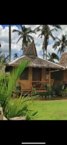 a house with palm trees in front of it at Green Soul Port Barton in San Vicente