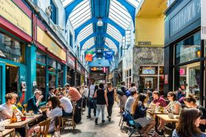 a crowd of people sitting at tables in a street with buildings at Spacious 2 Bed Apartment in Central Location in London