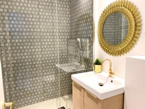 een badkamer met een wastafel en een douche met een spiegel bij PL2 - Stunning architect studio near Le Marais in Parijs
