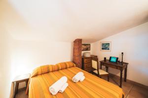 a bedroom with a bed and a desk with a laptop at Casa Zip in Marciana