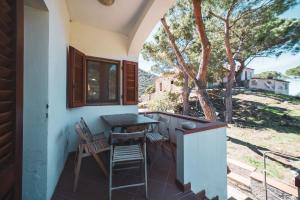 porche con mesa y sillas en el patio en Casa Zip en Marciana