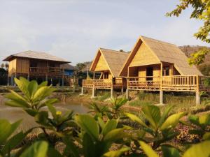 a resort with two houses and a pond at คูณ-เนื่อง ฟาร์ม สเตย์ หัวหิน Koon & Nueang Farm Stay Hua Hin in Ban Bo Fai